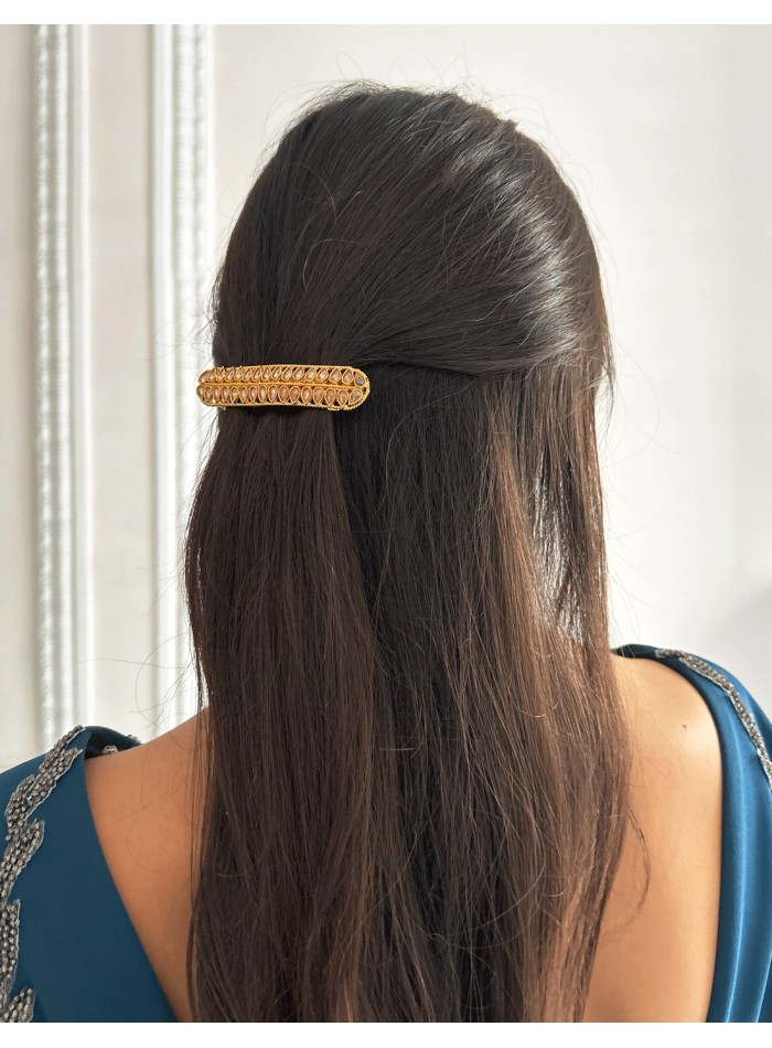 Golden barrette with pink crystals in the shape...