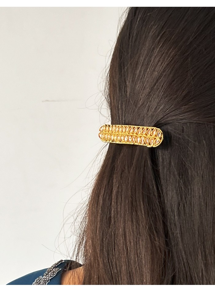 Golden barrette with pink crystals in the shape...