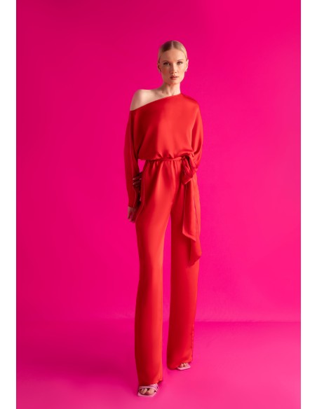 Asymmetric red jumpsuit with bat sleeves and belt