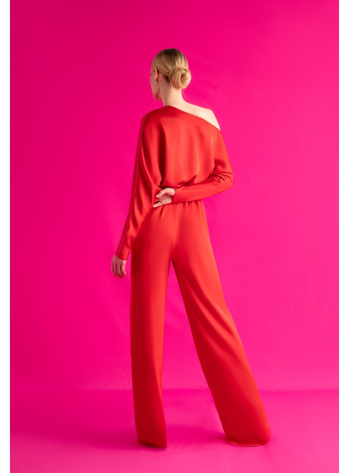Asymmetric red jumpsuit with bat sleeves and belt