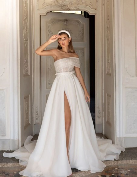 Robe de mariée avec encolure asymétrique et jupe fendue sur le côté