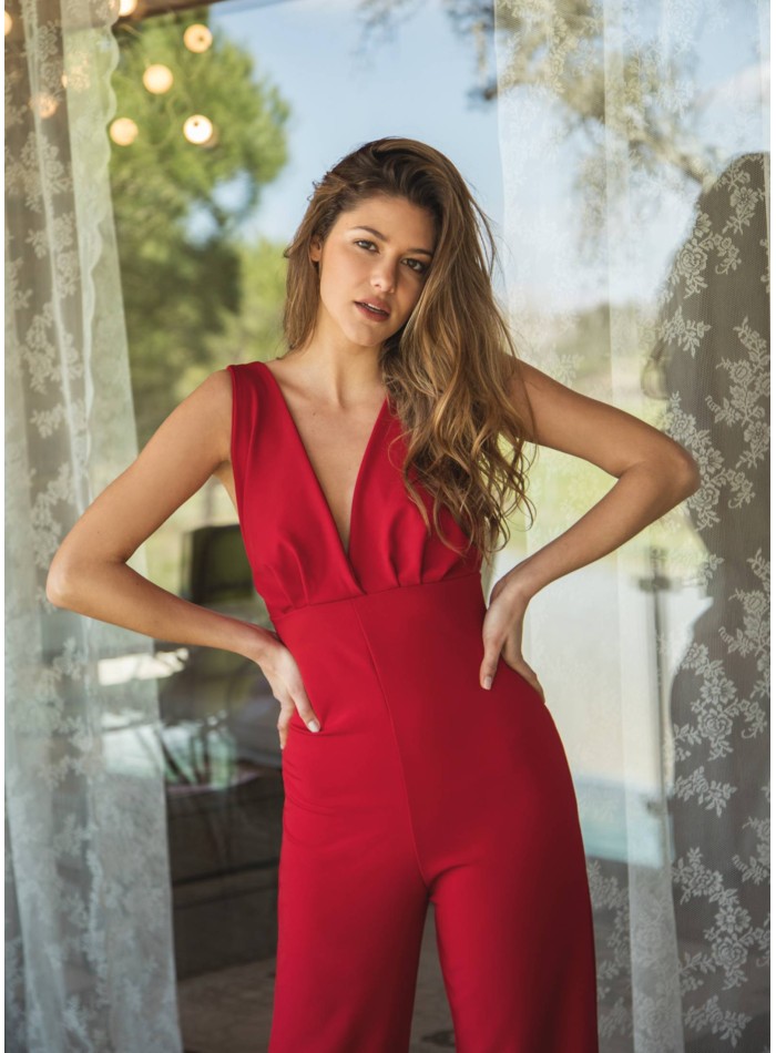 Red jumpsuit with wide straps and plunging neckline