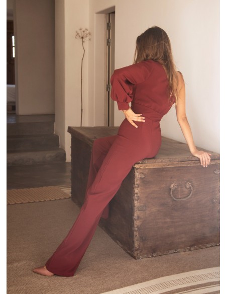 Long burgundy jumpsuit with asymmetrical neckline and long sleeves