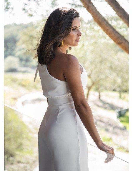 Longue combinaison blanche avec encolure asymétrique et laçage
