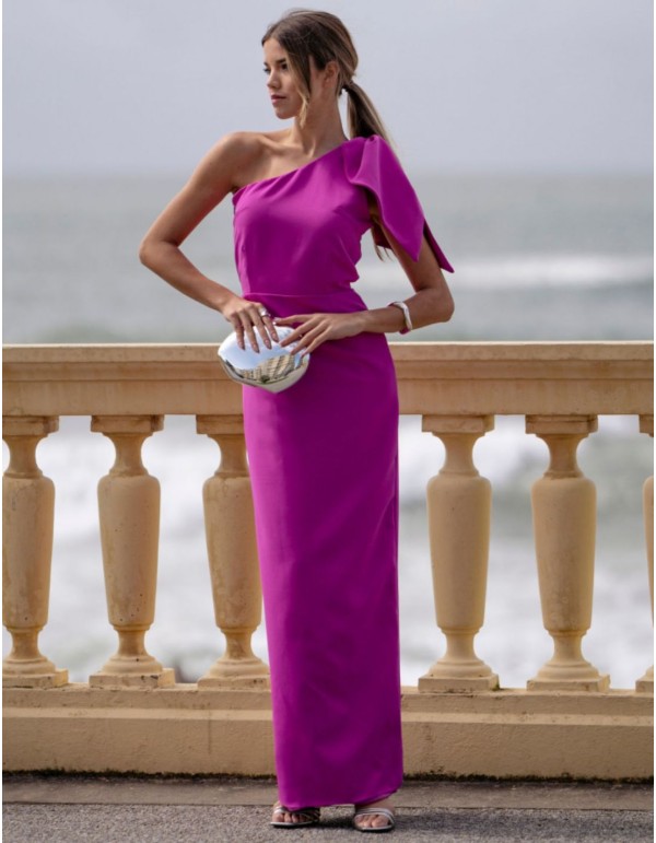 Vestido largo fucsia de invitada con escote asimétrico y lazada