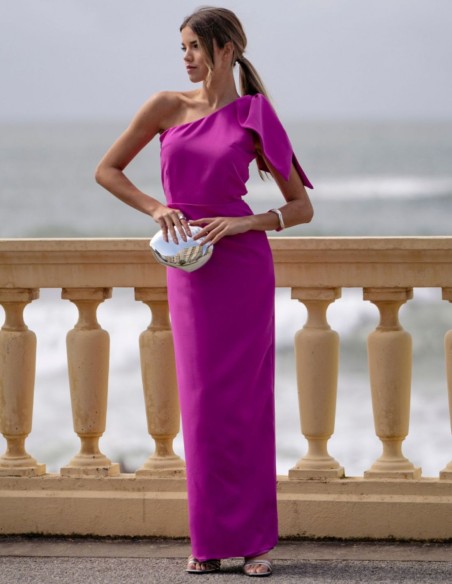 Vestido largo fucsia de invitada con escote asimétrico y lazada