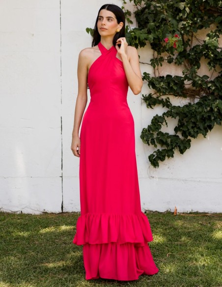 Longue robe d'invité de couleur fraise avec encolure licou croisée et volants sur la jupe