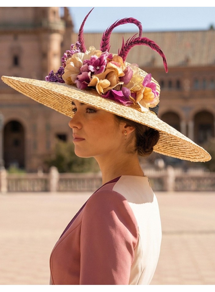 Pamela de rafia con detalle de flores y plumas en tono buganvilla para invitada