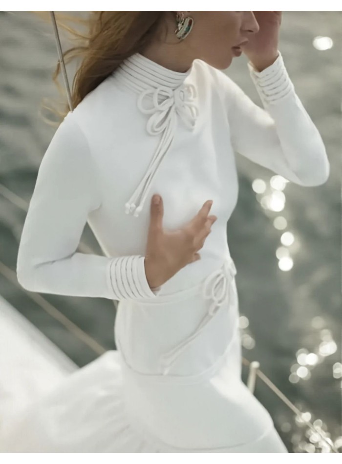 Vestido de novia de corte sirena con cuello alto y lazos decorativos