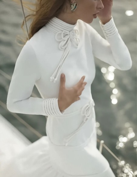 Vestido de novia de corte sirena con cuello alto y lazos decorativos