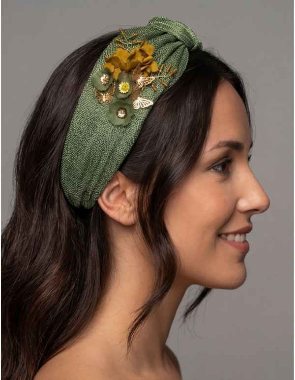 Diadema confeccionada en sinamay de seda verde con detalles de flores