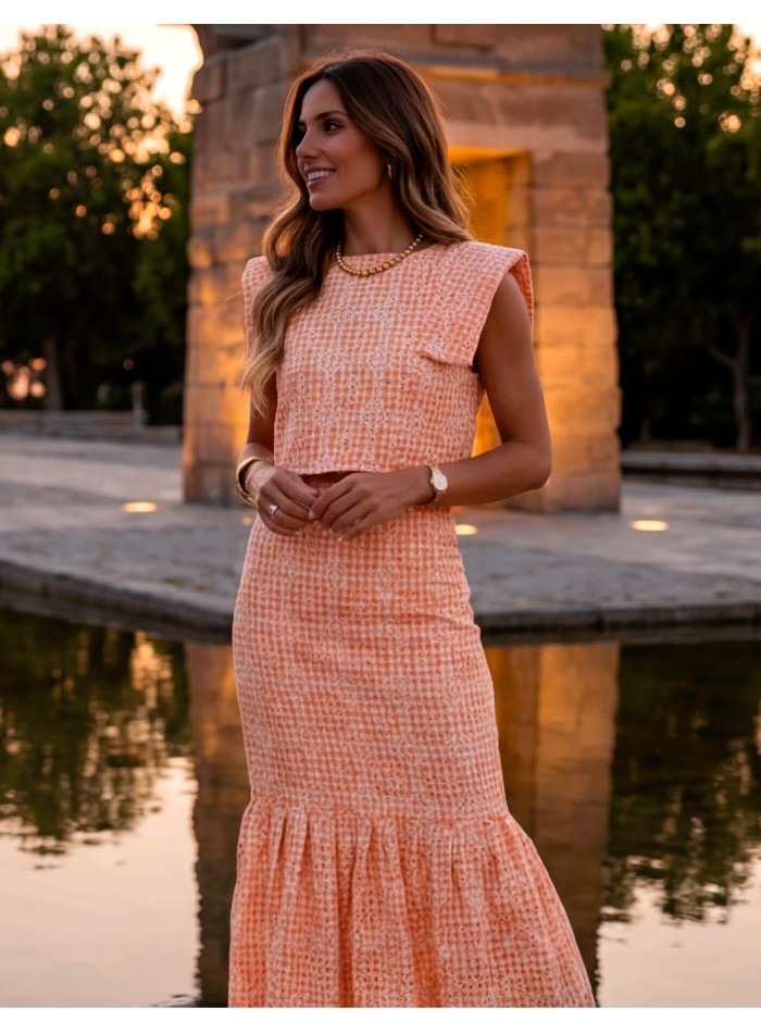 Orange two-piece wedding guest ensemble with midi skirt and structured top