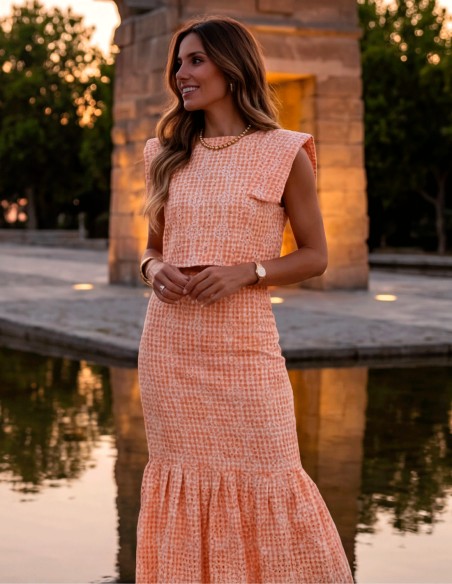 Orange two-piece wedding guest ensemble with midi skirt and structured top