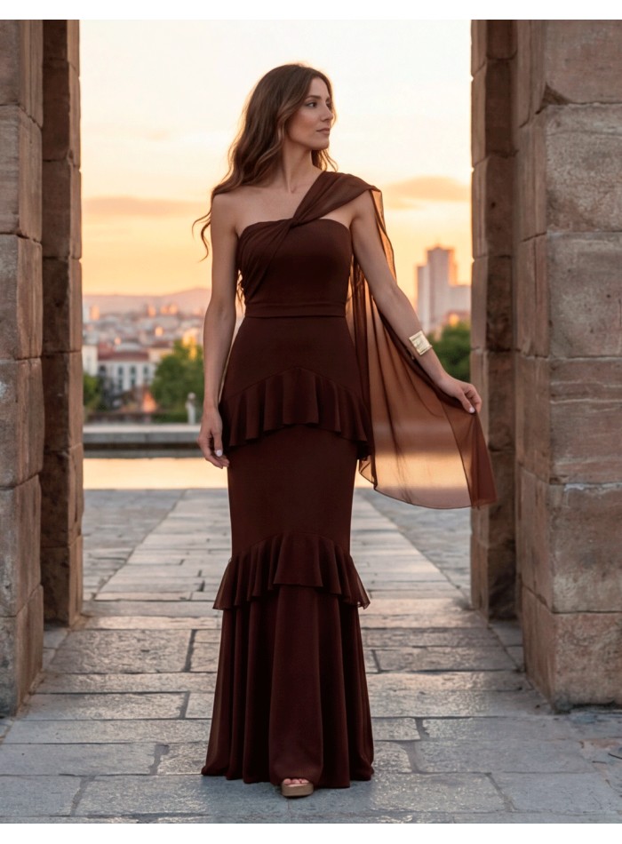 Long brown dress with asymmetrical neckline, cape and ruffles. An elegant, warm and very flattering design made in Spain.
