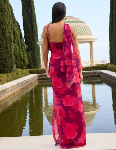 Long dress with asymmetrical neckline and fabric with floral motifs in purple tones