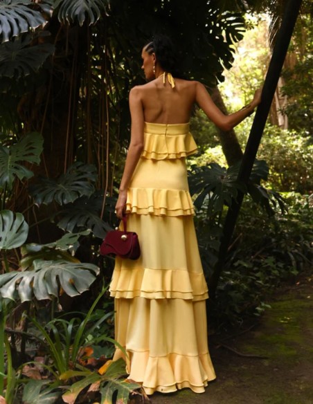 Long pastel yellow dress with halter neckline and ruffles