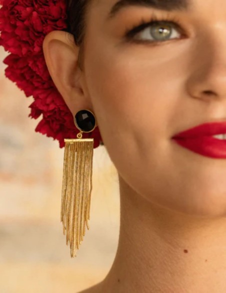 Long gold earrings with fringe and a black stone