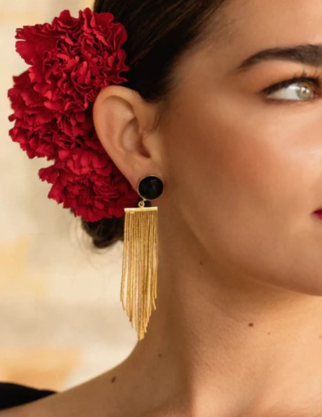 Long gold earrings with fringe and a black stone