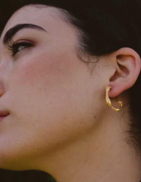 Small gold hoop earrings with a serpentine design