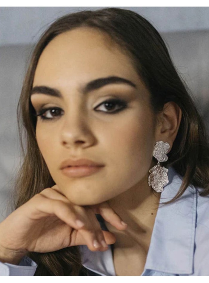 Long silver earrings consisting of two embossed...