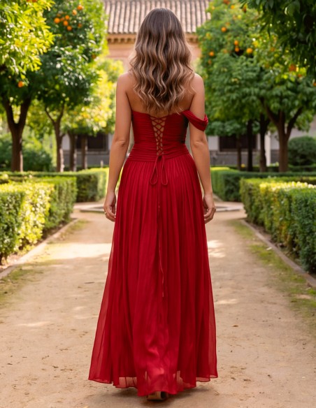 A long burgundy evening gown with a Bardot neckline, a draped bodice, and a full, flowing pleated skirt