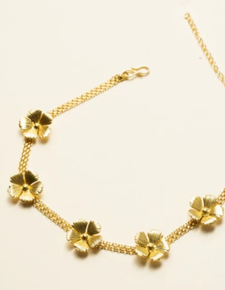 Collier ras-du-cou avec une large chaîne dorée ornée de motifs floraux
