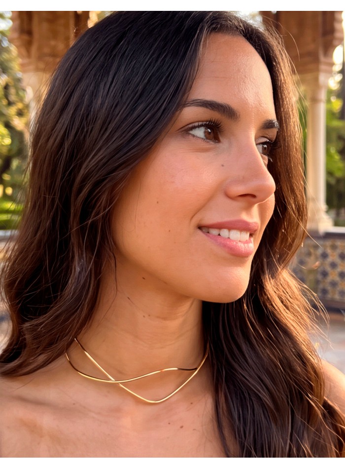 this rigid gold choker is proof that a simple design can become the absolute centerpiece of an outfit.