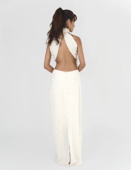 Long cream-colored dress with a halter neckline and an open back