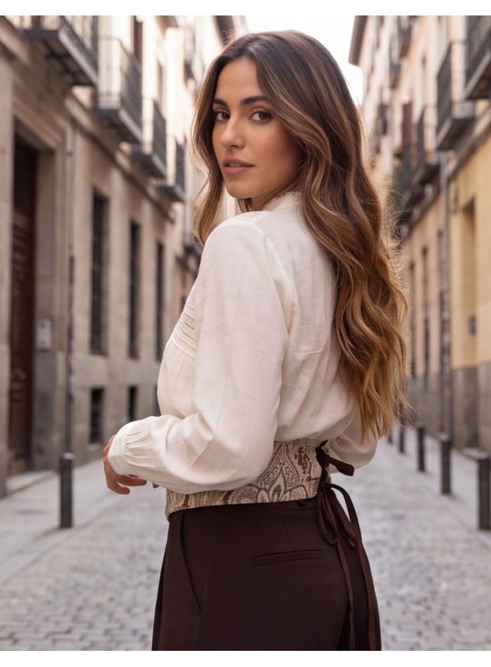 Parte trasera del fajín beige con dos lazadas para ajustar al cuerpo.