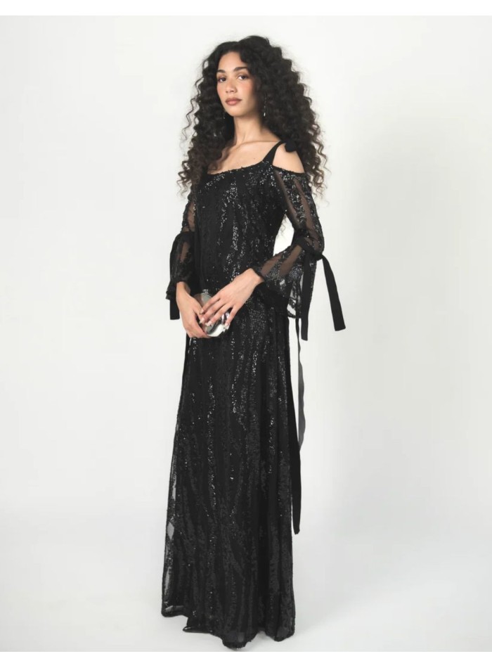 Vestido negro de tul bordado con lentejuelas, escote palabra de honor y mangas acampanadas.