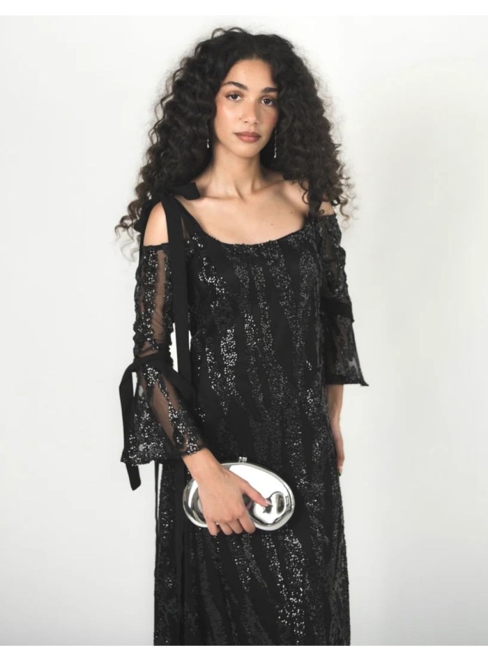 Gros plan sur les sequins noirs brodés sur le tulle de la robe.