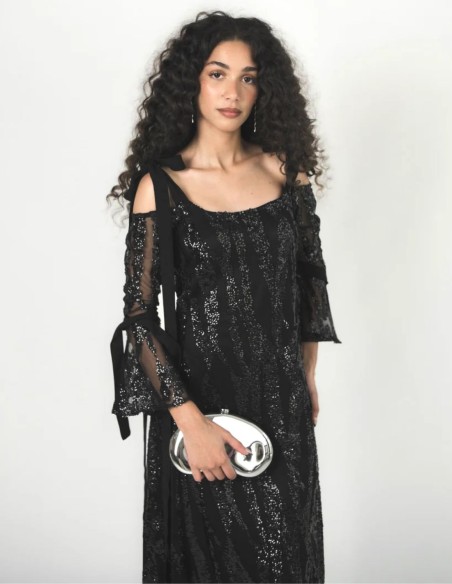 Gros plan sur les sequins noirs brodés sur le tulle de la robe.