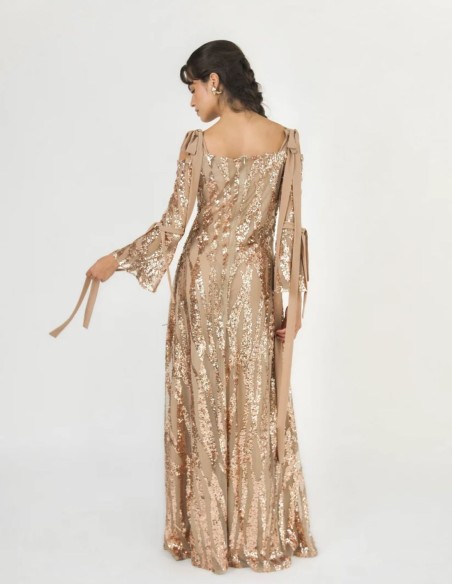 Détail du décolleté bustier et des bretelles réglables nouées en nœud de la robe champagne.