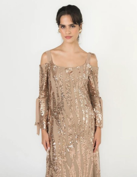 Gros plan sur les sequins couleur champagne brodés sur le tulle de la robe.