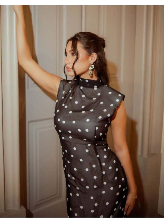 Robe noire d’inspiration orientale à silhouette droite et imprimé à pois blancs.