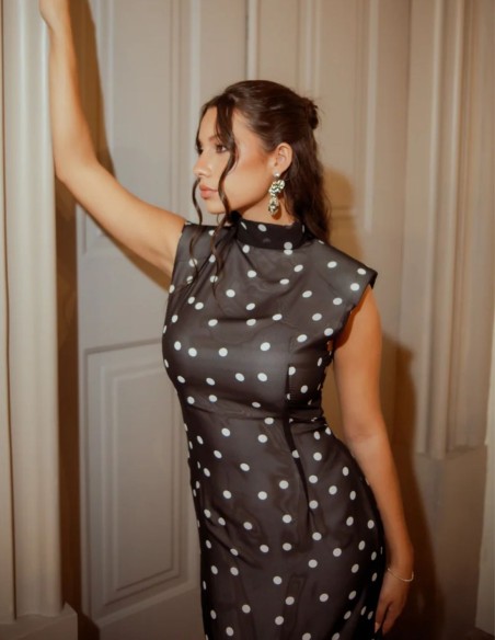 Fitted black dress with white polka dots, sleeveless design and structured neckline.
