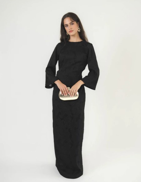 Robe longue noire en brocart, à manches longues papillon, silhouette ajustée et fente sur la jupe.