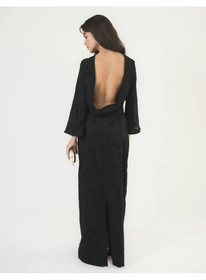 Long black brocade dress with long butterfly sleeves, fitted silhouette and skirt slit.