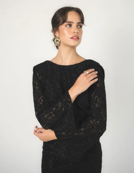 Long black velvet dress with an open back and a deep U-shaped neckline.