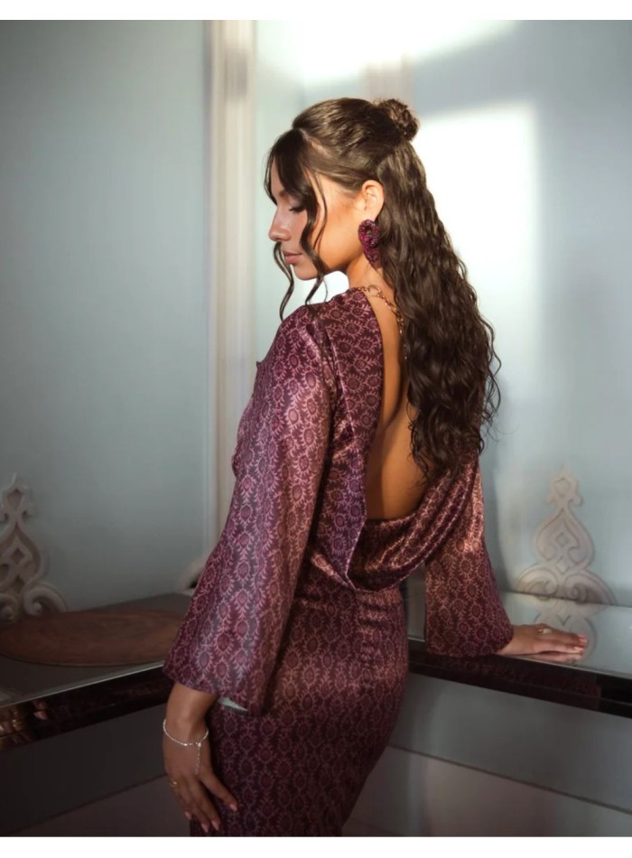 A long dress in shades of blackberry with small Arabic-inspired motifs and a subtle satin sheen