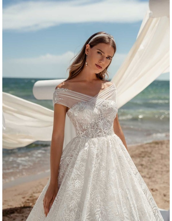 Vestido de novia con corte princesa con escote envolvente estilo bardot dejando los hombros al descubierto en INVITADISIMA 2
