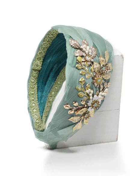 Diadema con base de plumas y detalle de joya dorada