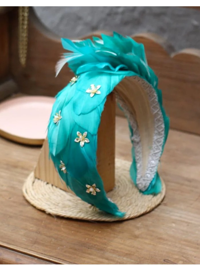 Diadema de plumas decorada con detalles joya esmeralda
