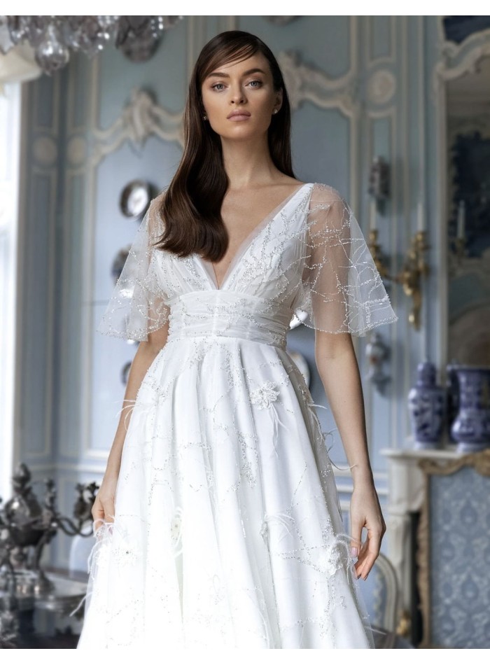 Wedding dress with sheer short sleeves and flowing skirt