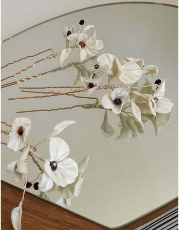 Horquillas blancas para novias con flores y detalles de pedrería.