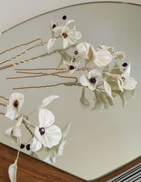White bridal hairpins with flowers and rhinestone details. White bridal hairpins with flowers and rhinestone details.