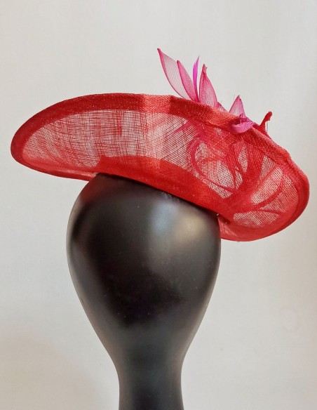 Tocado para invitadas estilo plato con plumas y flores.