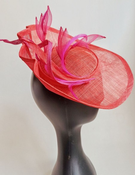 Tocado con ala plisada y plumas y flores en rosa.