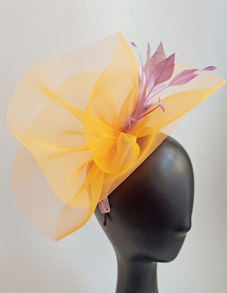 Yellow raffia headdress with mauve feathers.