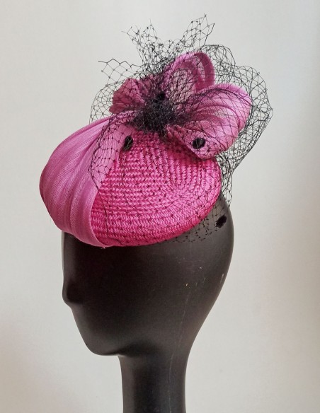 Tocado de sinamay de seda en color fucsia y tul de rejilla negro. Tocado de sinamay de seda en color fucsia y tul de rejilla negro.